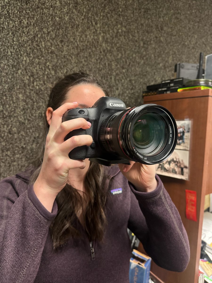 Emory Loughry holding a camera,
photo by Caroline Schwebach.