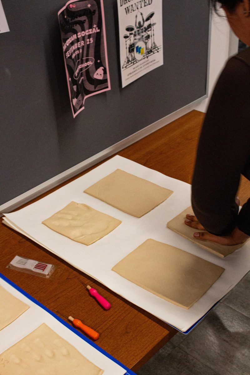 Giselle Terrazas Saldana, making a hand print into the clay block